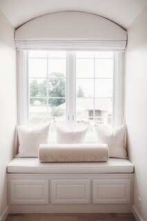 custom made nursery window seat with custom made roman shade and pillows